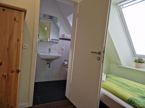 a small bathroom with a sink and a toilet at Haus Regenpfeifer in Büsum