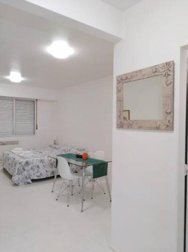 a white room with a bed and a table and chairs at Studio Aguero - Recoleta in Buenos Aires