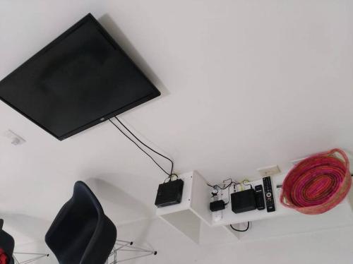 Un televisor en una pared con una cuerda roja. en Studio Aguero - Recoleta en Buenos Aires