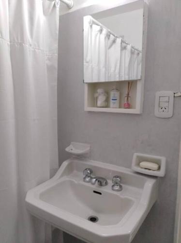 a white bathroom with a sink and a mirror at Studio Aguero - Recoleta in Buenos Aires