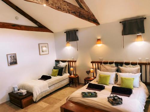 1 dormitorio con 2 camas y almohadas verdes y blancas en "La Petite Félixière" en Saint-André-de-la-Marche