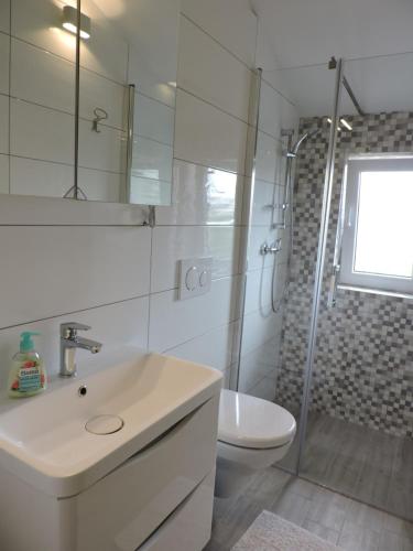 a bathroom with a sink and a toilet and a shower at Apartman IV ( 2 + 2 ) in Vodnjan
