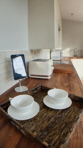 a table with three white plates and a toaster at Holly Cottage, Hidden gem in the Yorkshire wolds in Welton