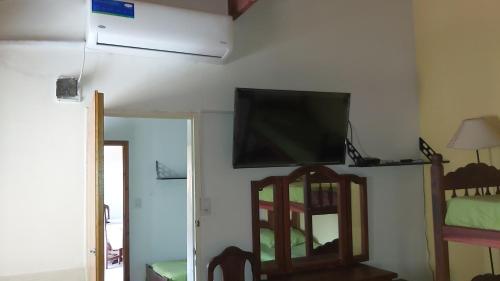 a living room with a flat screen tv on a wall at Chapadmalal Casas La Bella in Colonia Chapadmalal