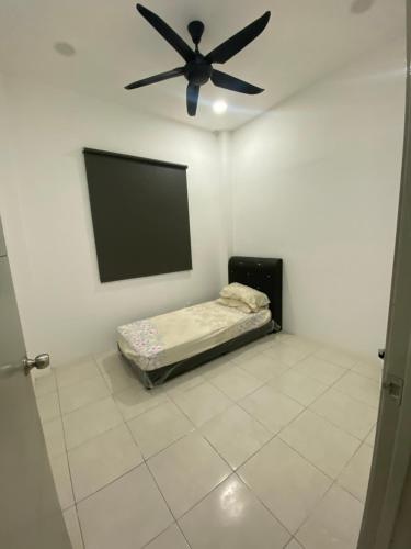 a room with a bed and a ceiling fan at The Vista Apartment @ Demak Laut in Kuching