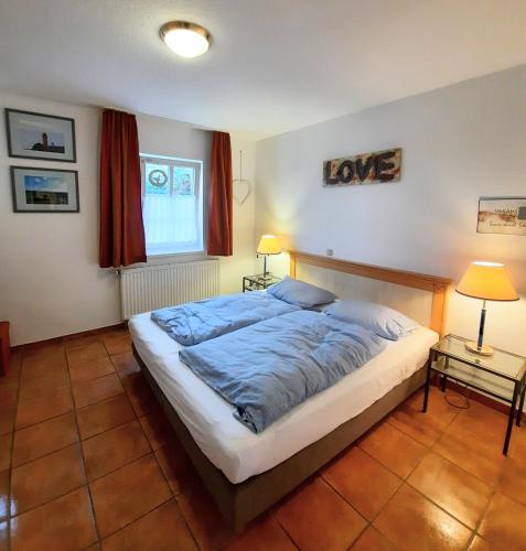 a bedroom with a large bed in a room with red curtains at Sonne in Neddesitz