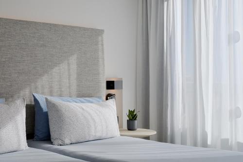 a bedroom with a bed with blue and white pillows at INNSiDE by Meliá Barcelona Apolo in Barcelona