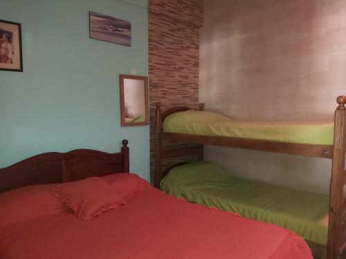 a bedroom with two bunk beds and a red bed at Chapadmalal Casas La Bella in Colonia Chapadmalal