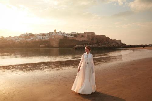 a woman in a white dress standing on the beach at Fairmont La Marina Rabat Sale Hotel in Rabat