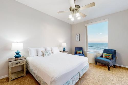 a bedroom with a bed and a window with the ocean at Spanish Key 408 in Pensacola