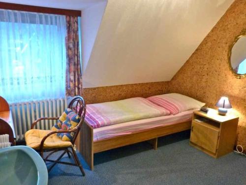 內貝爾的住宿－Friedrichs-5-EZ，卧室配有床、椅子和窗户。