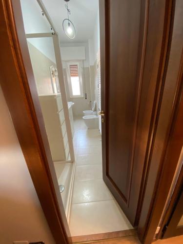 eine offene Tür zu einem Bad mit WC in der Unterkunft Hlux OI ₐffᵢₜₜₐCₐₘₑᵣₑ in Piacenza