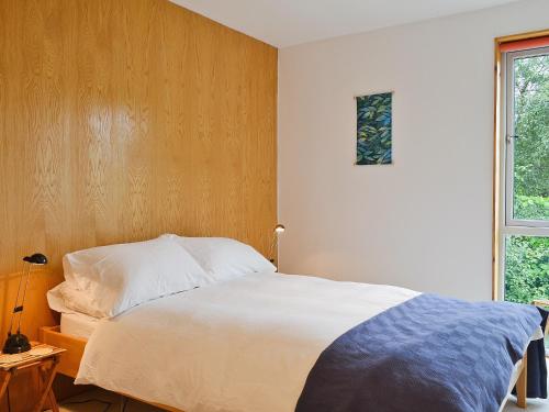 - une chambre avec un grand lit blanc et une fenêtre dans l'établissement West Bothy, à Glenborrodale