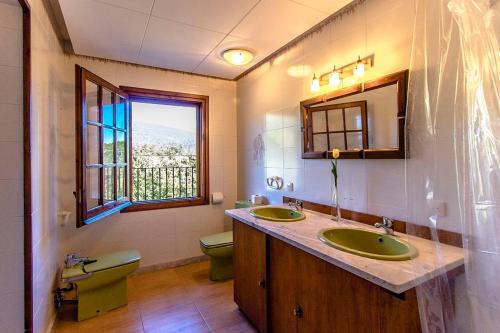 a bathroom with two sinks and a toilet and a window at Catalunya Casas Nature and Tranquility for 24 pax - 30km to beach in Sant Pere de Vilamajor