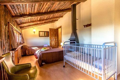 Sant Pere de VilamajorにあるCatalunya Casas Nature and Tranquility for 24 pax - 30km to beachのベッドルーム1室(ベッド1台、ベビーベッド1台付)