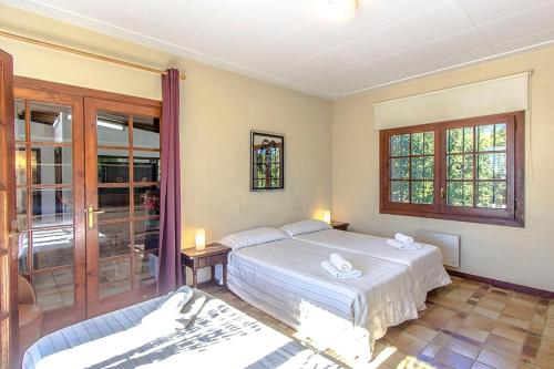 a bedroom with a bed and a sliding glass door at Catalunya Casas Nature and Tranquility for 24 pax - 30km to beach in Sant Pere de Vilamajor
