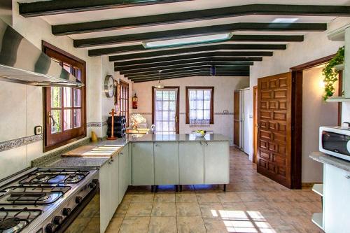 a large kitchen with white cabinets and a stove at Catalunya Casas Nature and Tranquility for 24 pax - 30km to beach in Sant Pere de Vilamajor
