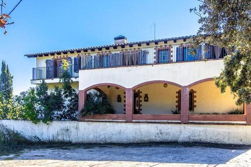 a large yellow and white house with a balcony at Catalunya Casas Nature and Tranquility for 24 pax - 30km to beach in Sant Pere de Vilamajor