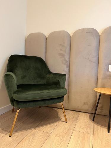 a green chair sitting in front of a wall at Tirana Center Hideaway in Tirana