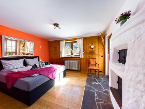 een slaapkamer met oranje muren, een bed en een open haard bij Schnitzerstube in Mittenwald