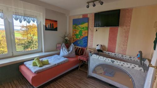 a bedroom with a bed and a tv and a fireplace at Landhaus "Kühler Morgen", Komfortable 65 qm FeWo mit gehobener Ausstattung, Garten, baby- und kindgerecht in Saalburg