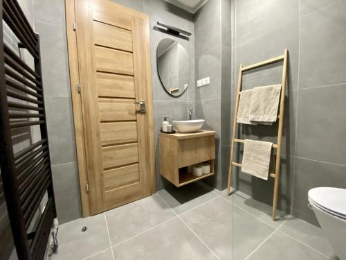 y baño con lavabo, aseo y espejo. en Apartmány Kellov Dom en Demanovska Dolina
