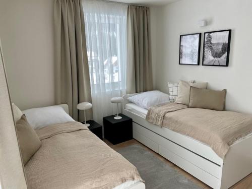 um quarto com 2 camas e uma janela em Apartmány Kellov Dom em Demanovska Dolina