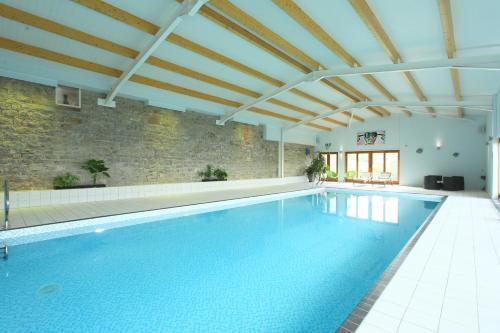 an indoor swimming pool with a brick wall at Dumble Cottage in Ashbourne