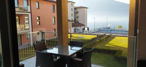 een balkon met een tafel en uitzicht op een straat bij Golfo Gabella Lake Resort in Maccagno Superiore