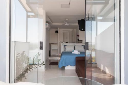 a bedroom with a bed with a blue blanket at Suítes Luxo Marambaia- Epic House in Rio de Janeiro
