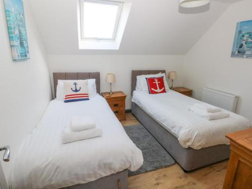 um quarto com 2 camas e uma janela em The Boathouse em Tenby