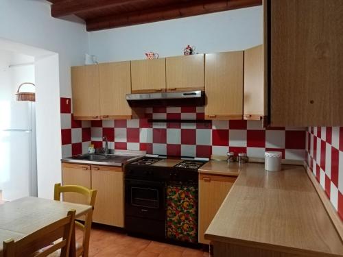 - une cuisine avec un poêle noir et du carrelage rouge et blanc dans l'établissement La casa di Gaia, à Cabras