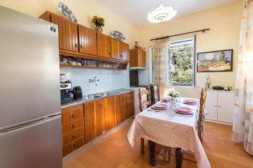 a kitchen with a table and a refrigerator at The Old Well, Spacious House in North Corfu in Perítheia