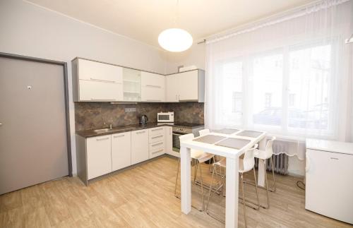 cocina con armarios blancos y mesa blanca en Libušina Villa, en Kutná Hora