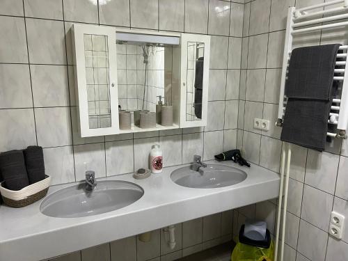 a bathroom with two sinks and a mirror at Sandys Ferienwohnung im Grünen in Niederdorf