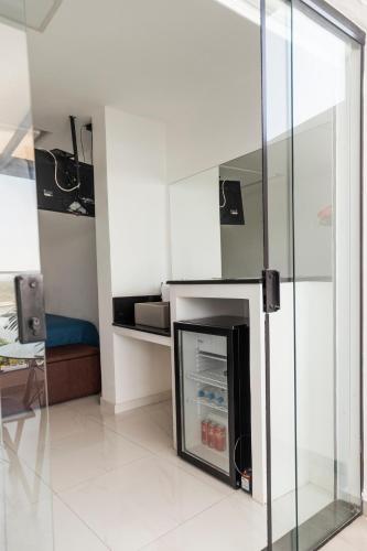 a living room with a refrigerator in a room at Suítes Luxo Marambaia- Epic House in Rio de Janeiro