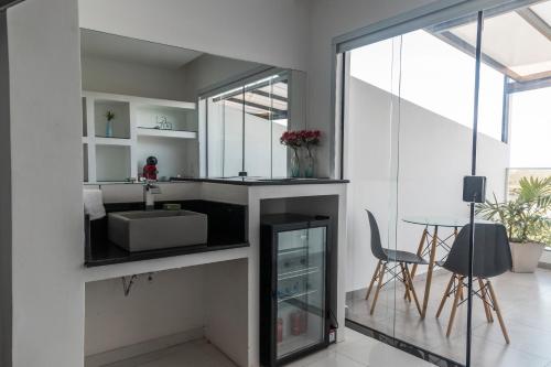 a bathroom with a sink and a mirror at Suítes Luxo Marambaia- Epic House in Rio de Janeiro