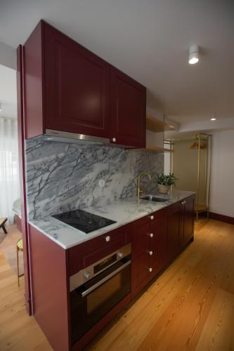 a kitchen with a marble counter top and a sink at Trovador Guest House in Guimarães