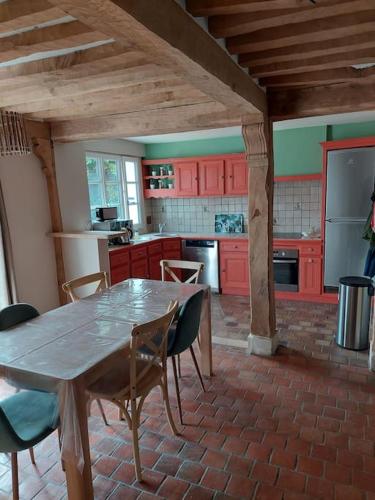 une cuisine avec des armoires rouges et une table et des chaises dans l'établissement Un Brin de folie dans le centre de Honfleur, à Honfleur