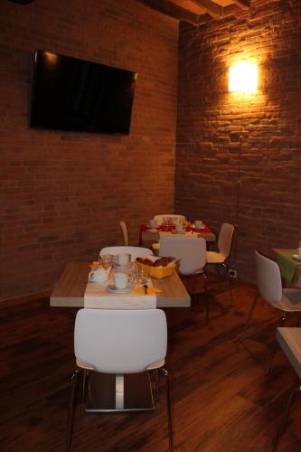 una sala da pranzo con tavolo, sedie e televisione di Albergo Da Ca' Vecia a Spilamberto