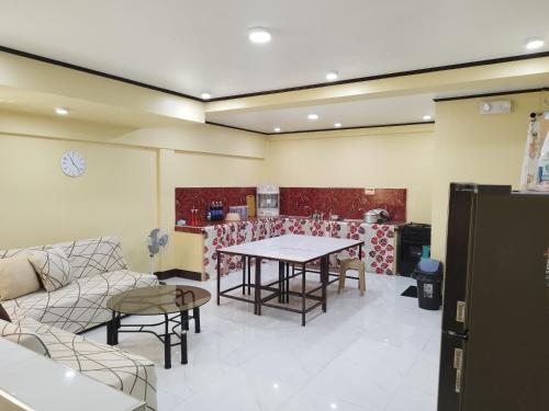 Habitación con mesa, sillas y cocina. en 30pax-Jumongs Transient Inn, en Bantay