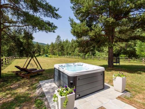 uma banheira de hidromassagem sentada no meio de um quintal em Apartments Plitvice forest em Korenica