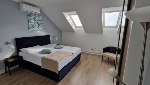 a bedroom with a bed and two windows at Apartment Residence Bratislava FREE PARKING in Bratislava