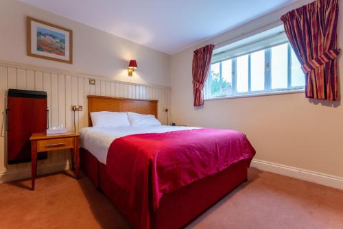 a bedroom with a large bed and a window at The Evenhill in Canterbury