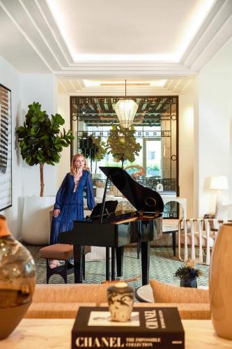 a woman sitting at a piano in a living room at Fairmont La Marina Rabat Sale Hotel in Rabat