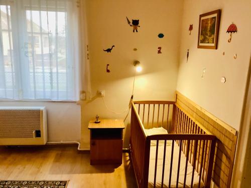 een babykamer met een wieg en aaningrogram bij Margaréta Vendégház in Fehérvárcsurgó