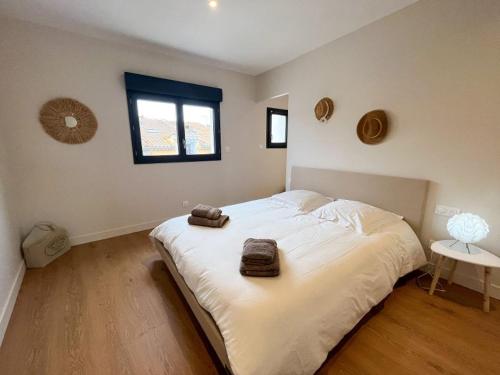 ein Schlafzimmer mit einem großen Bett mit zwei Handtüchern darauf in der Unterkunft Agréable maison de village avec garage & terrasse in Lespignan
