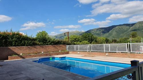 a swimming pool with mountains in the background at Mardi - Departamentos de alquiler temporario in Bialet Massé