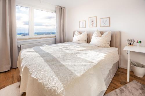 Un pat sau paturi într-o cameră la Moderne 2-Zimmer-Wohnung mit atemberaubender Skyline Aussicht auf Frankfurt!