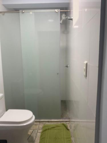 a bathroom with a toilet and a glass shower at CASA DE PLAYA ROCKY CAY BAY in Cueva de Morgan